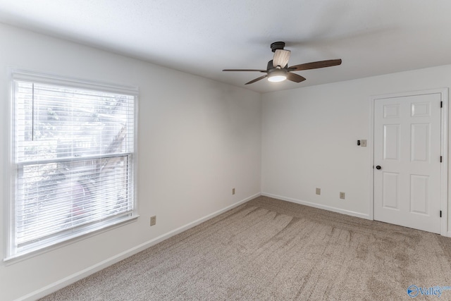 carpeted spare room featuring ceiling fan