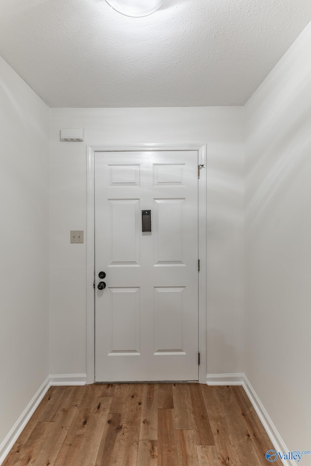 entryway with light hardwood / wood-style flooring and a textured ceiling