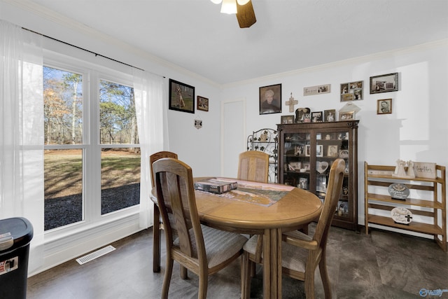 dining space with ceiling fan and crown molding