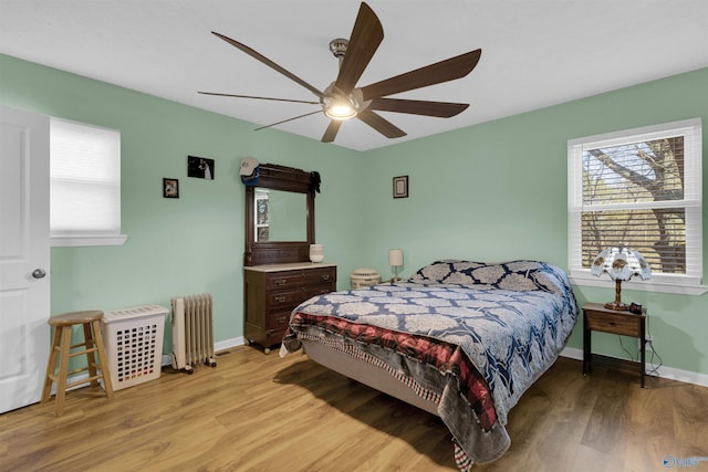 bedroom featuring ceiling fan, light hardwood / wood-style floors, and radiator heating unit