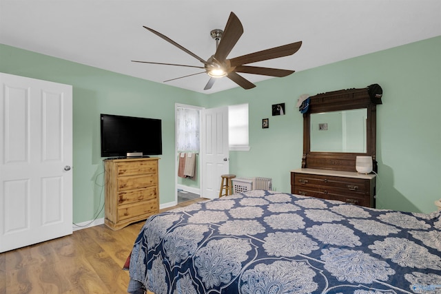 bedroom with ceiling fan, connected bathroom, and light hardwood / wood-style floors