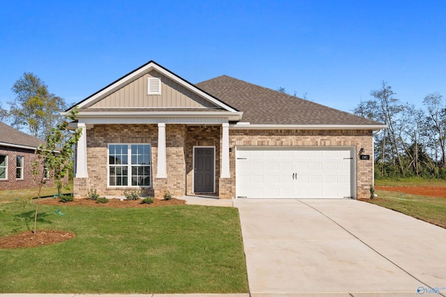 craftsman-style house featuring brick siding, board and batten siding, a front yard, a garage, and driveway