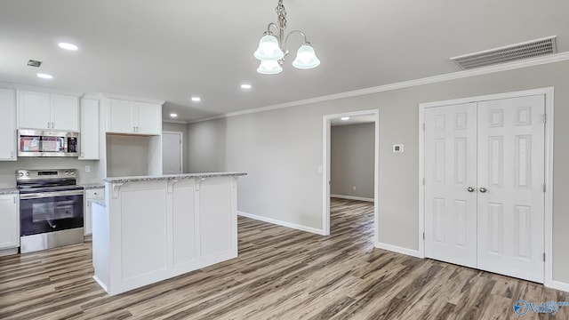 kitchen with a kitchen island, white cabinets, a chandelier, and appliances with stainless steel finishes