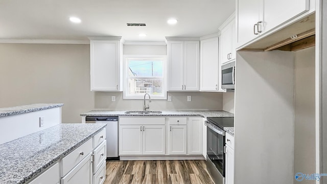 kitchen with white cabinets, light stone countertops, sink, and appliances with stainless steel finishes