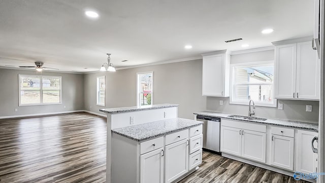 kitchen with dishwasher, a center island, white cabinetry, and sink