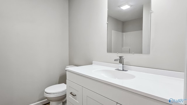 bathroom featuring a shower, vanity, and toilet