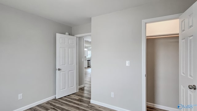 unfurnished bedroom featuring dark wood-type flooring and a closet