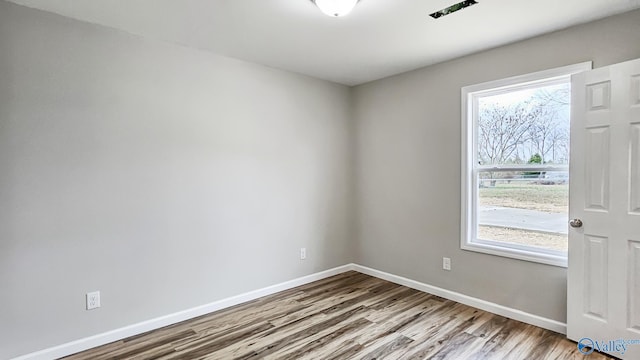 spare room featuring light hardwood / wood-style flooring and plenty of natural light