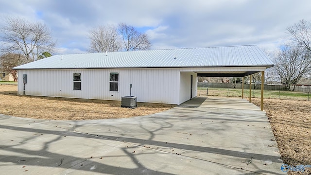 view of property exterior featuring central AC unit and a carport