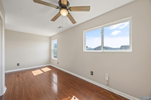 empty room featuring a ceiling fan, wood finished floors, and baseboards