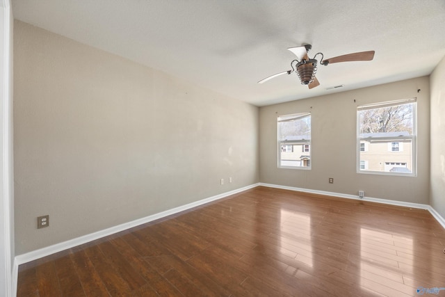 unfurnished room featuring visible vents, baseboards, ceiling fan, and hardwood / wood-style flooring