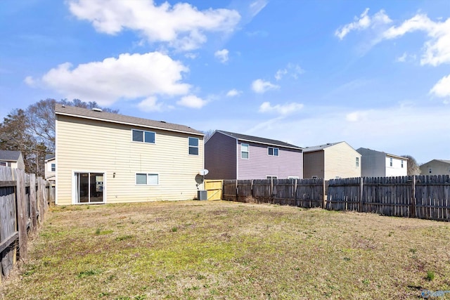 rear view of property featuring a residential view, a lawn, and a fenced backyard