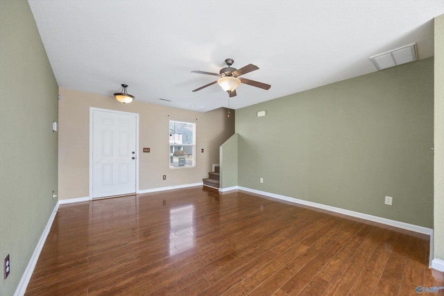 unfurnished living room with visible vents, baseboards, ceiling fan, stairway, and wood finished floors