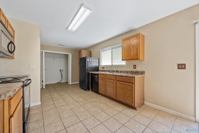 kitchen featuring light tile patterned floors, black appliances, baseboards, and a sink