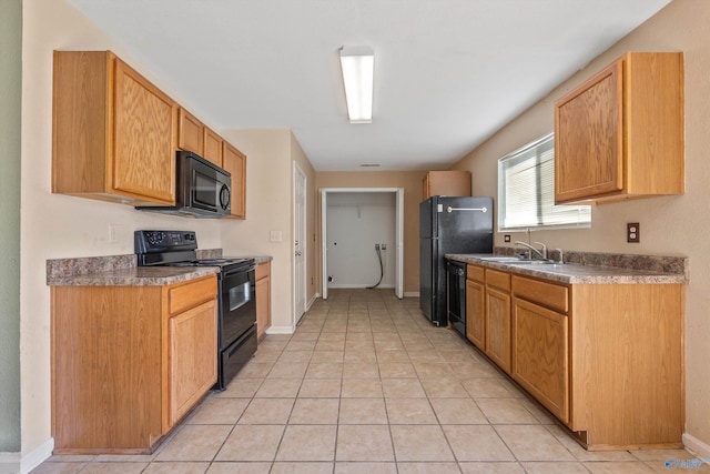 kitchen featuring black appliances, light tile patterned flooring, and baseboards