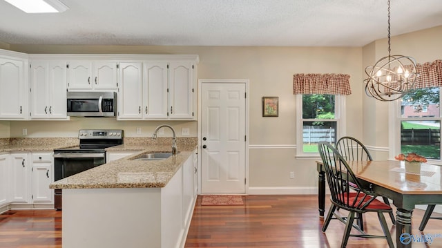 114 Spring Water Dr, Madison, AL 35758 - kitchen with appliances with stainless steel finishes, a sink, dark wood finished floors, white cabinets, and a textured ceiling