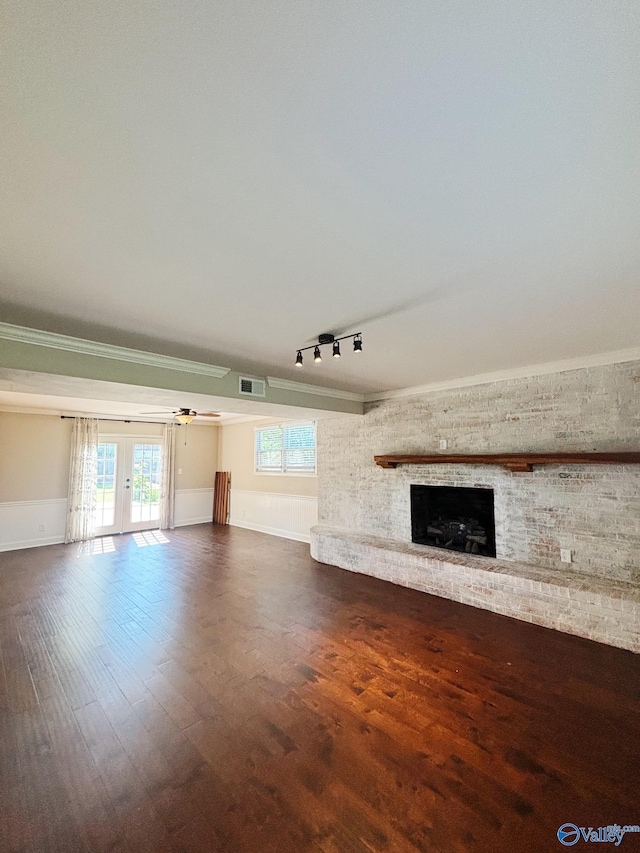 5627 SW Alta Dena St, Huntsville, AL 35802 - unfurnished living room with a brick fireplace, wood finished floors, french doors, plenty of natural light, and ornamental molding