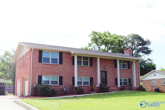 5627 SW Alta Dena St, Huntsville, AL 35802 - view of front of home with an attached garage, a chimney, a front yard, and brick siding