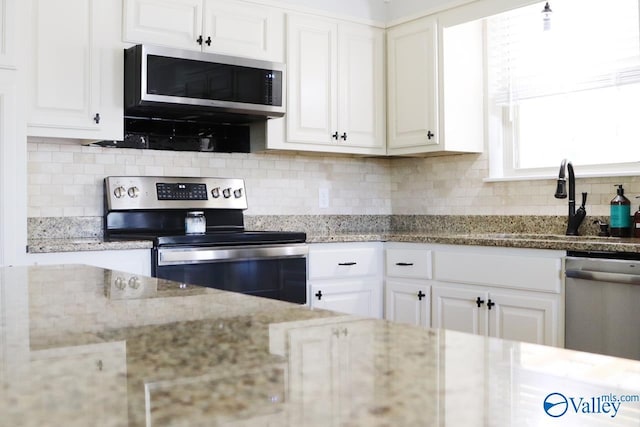5627 SW Alta Dena St, Huntsville, AL 35802 - kitchen featuring stainless steel appliances, white cabinetry, tasteful backsplash, and light stone counters