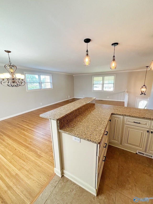 5627 SW Alta Dena St, Huntsville, AL 35802 - kitchen featuring ornamental molding, cream cabinetry, open floor plan, light stone countertops, and decorative light fixtures