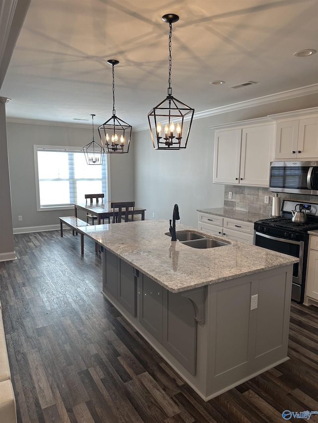 kitchen featuring white cabinetry, appliances with stainless steel finishes, light stone countertops, and sink