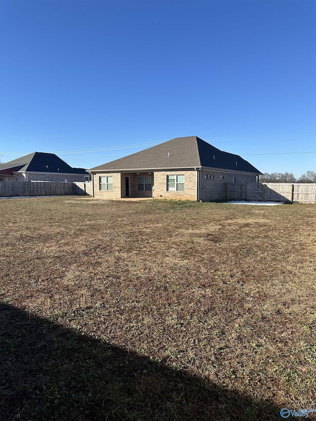 rear view of house featuring a lawn