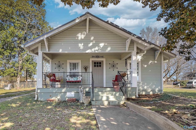 bungalow-style home featuring a porch and fence