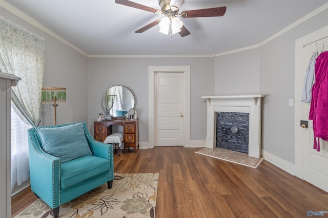 living area featuring a tile fireplace, wood finished floors, baseboards, and ornamental molding