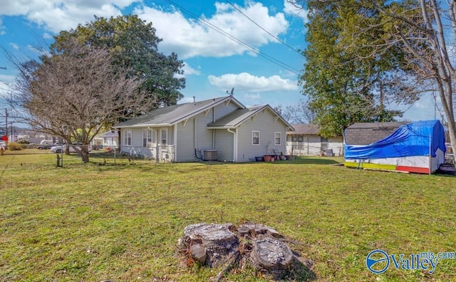 view of property exterior with central AC unit, a lawn, and fence