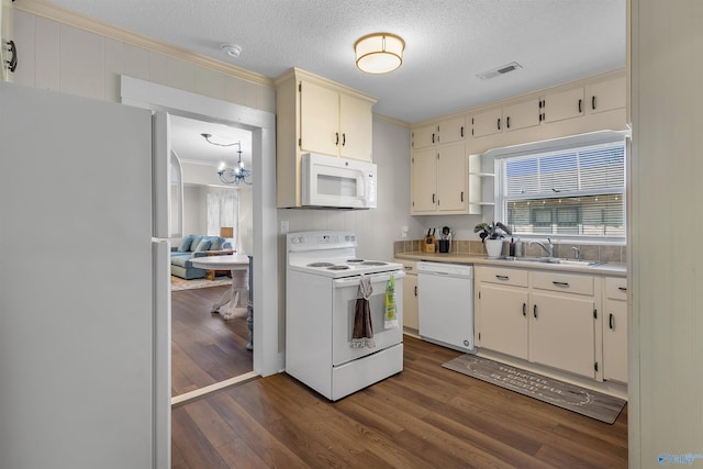 kitchen with white appliances, a sink, dark wood-type flooring, light countertops, and crown molding