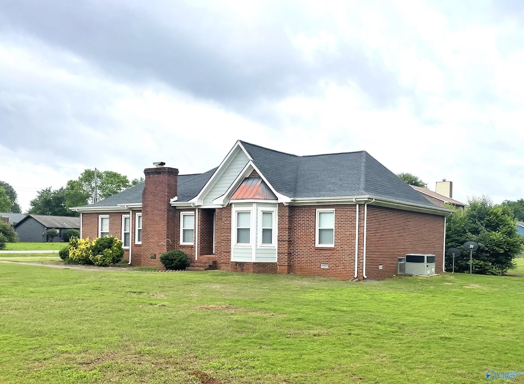 118 Hazelwood Dr, Hazel Green, AL 35750 - view of front facade with a chimney, brick siding, and a front yard