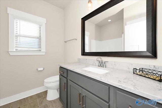 bathroom featuring tile patterned floors, vanity, toilet, and walk in shower