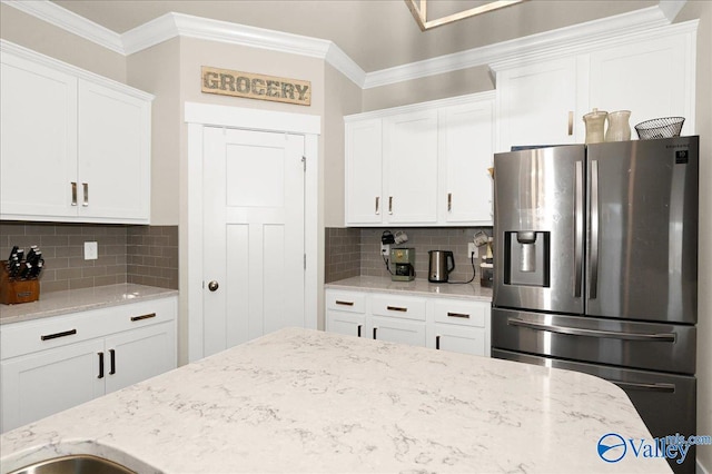 kitchen featuring white cabinets, stainless steel fridge with ice dispenser, and tasteful backsplash