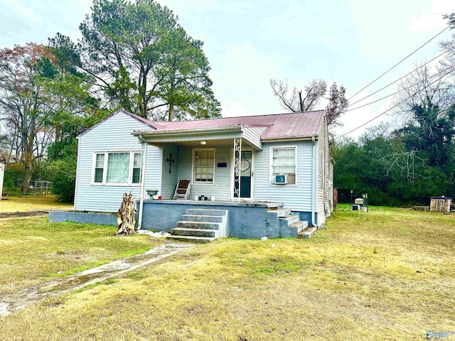 bungalow featuring covered porch, a front lawn, and cooling unit