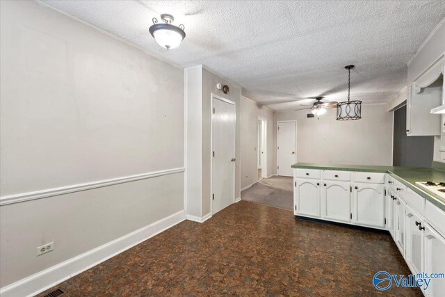 kitchen featuring tile patterned flooring, kitchen peninsula, a textured ceiling, white cabinetry, and ceiling fan