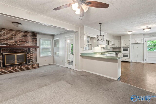 kitchen featuring white cabinets, ceiling fan, carpet, and kitchen peninsula