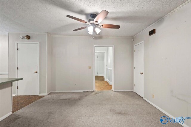 interior space featuring a textured ceiling, carpet, and ceiling fan