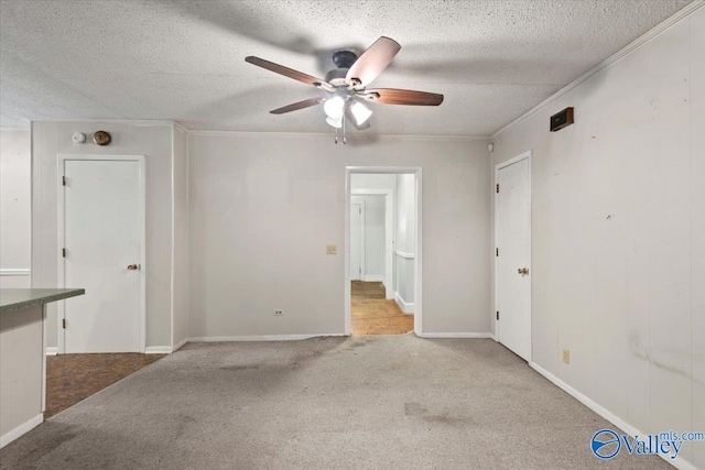 unfurnished room with a textured ceiling, crown molding, a ceiling fan, and carpet floors