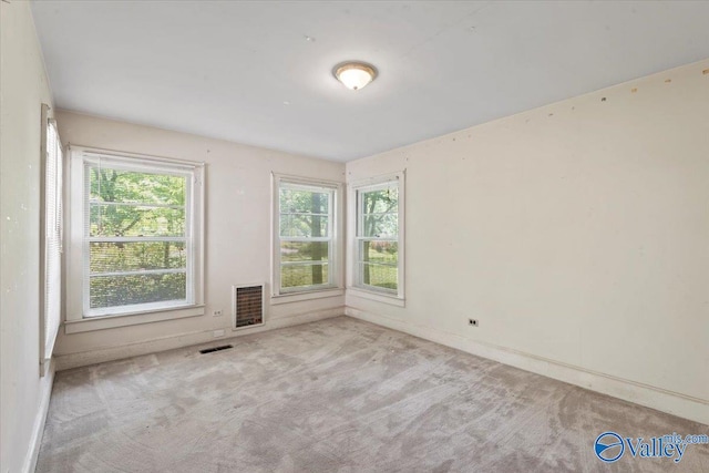 carpeted spare room featuring visible vents
