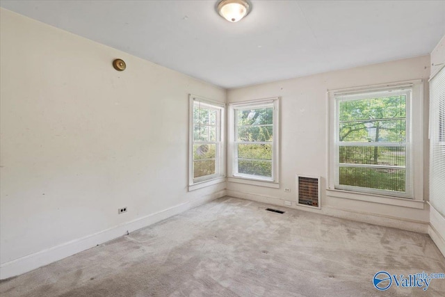 spare room with visible vents, a healthy amount of sunlight, and carpet
