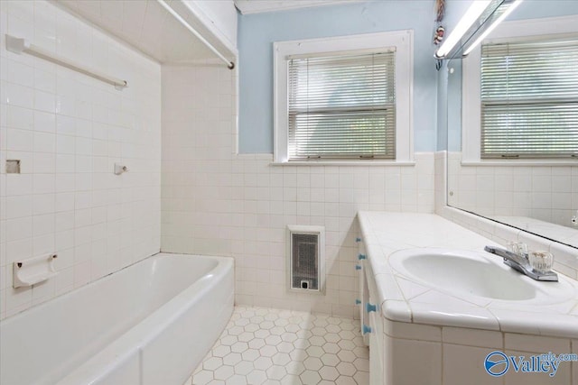full bath featuring tile patterned flooring, visible vents, a tub, tile walls, and vanity
