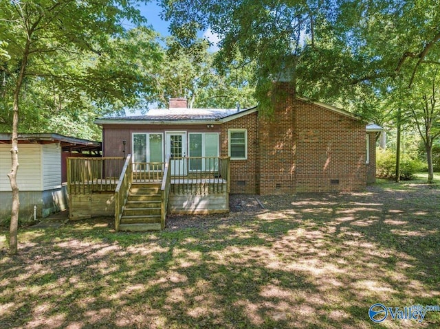 back of property with a wooden deck, a chimney, and crawl space