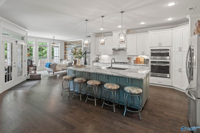 155 Holbrook Dr, Huntsville, AL 35806 - kitchen featuring appliances with stainless steel finishes, white cabinets, ornamental molding, a breakfast bar, and light stone countertops