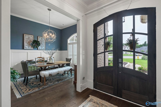 155 Holbrook Dr, Huntsville, AL 35806 - foyer entrance featuring dark wood-type flooring, a chandelier, a wainscoted wall, ornamental molding, and arched walkways
