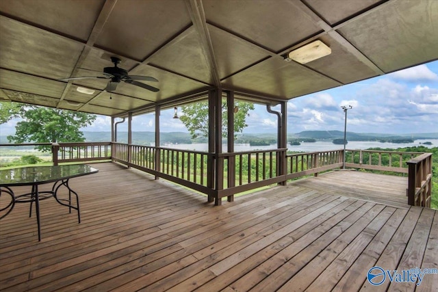 deck with a water and mountain view and a ceiling fan