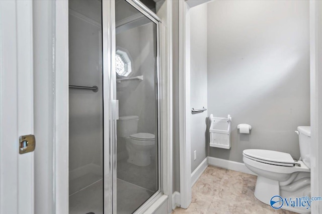 bathroom with baseboards, a shower stall, and toilet