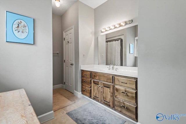 bathroom with a shower with curtain, baseboards, and vanity