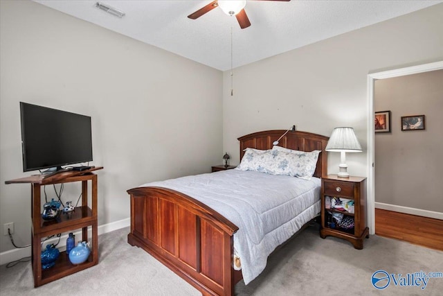 bedroom featuring light carpet, baseboards, visible vents, and ceiling fan