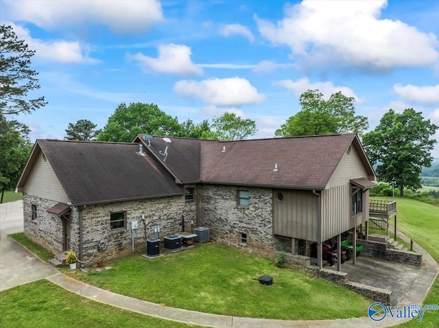 back of house with stairs, a yard, roof with shingles, and central AC