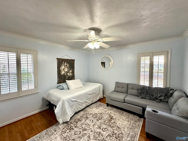 bedroom with hardwood / wood-style flooring, a textured ceiling, ceiling fan, and crown molding